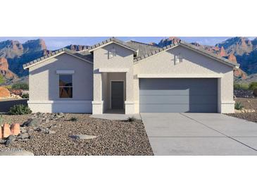 Charming single-story home with a two-car garage and desert landscaping in front at 38055 W Bello Ln, Maricopa, AZ 85138