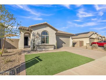 Beautiful single-story home featuring a manicured front yard and a paver driveway leading to a two-car garage at 41260 W Palmyra Ln, Maricopa, AZ 85138