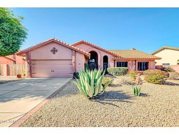 Charming single-story home with a tile roof, desert landscaping, and attached two-car garage at 5421 E Michelle Dr, Scottsdale, AZ 85254