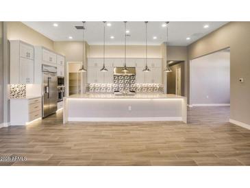 Spacious kitchen featuring a large center island, pendant lighting, stainless steel appliances, and tile backsplash at 7210 E Camino Rayo De Luz --, Scottsdale, AZ 85266