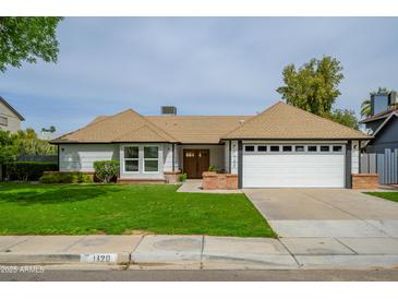 Charming single Gathering home with a well manicured lawn, attached garage, and quaint brick accents at 1120 W Barrow Dr, Chandler, AZ 85224