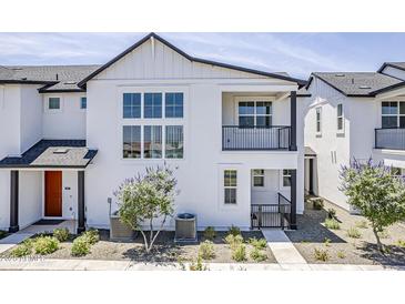 Stylish two-story home featuring a balcony, large windows, and modern architectural details at 11300 N Casa Dega Dr # 1006, Surprise, AZ 85388