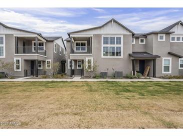 Charming townhome exterior with multiple levels, gray stucco, and a well-maintained lawn at 11300 N Casa Dega Dr # 1020, Surprise, AZ 85388