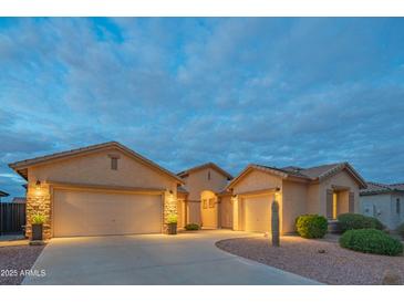 Charming single-story home featuring a three-car garage and well-manicured desert landscaping at 15290 W Ventura St, Surprise, AZ 85379