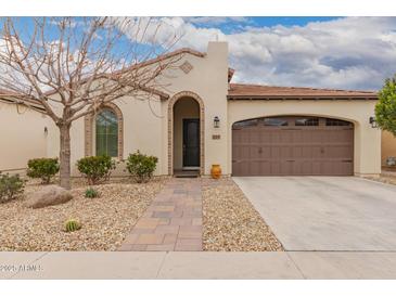 Charming single-story home featuring a desert landscape, paved walkway, and a two-car garage at 229 E Alcatara Ave, Queen Creek, AZ 85140