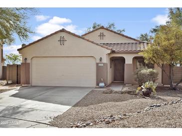 Charming single-story home with a two-car garage, tile roof, and low-maintenance desert landscaping at 36765 W Mediterranean Way, Maricopa, AZ 85138