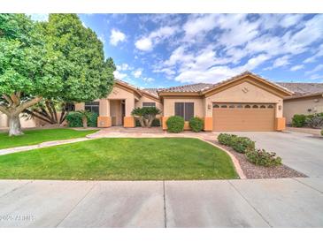Charming home featuring lush green lawn, mature shade tree, and meticulously maintained desert landscaping at 3682 S Rosemary Dr, Chandler, AZ 85248