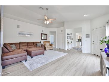 Inviting living room featuring a comfortable sectional sofa, ceiling fan, and stylish decor at 3925 W Hackamore Dr, Phoenix, AZ 85083