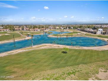 Scenic aerial view of a golf course community with lush greenery and a beautiful blue pond at 4538 E Shomi St, Phoenix, AZ 85044