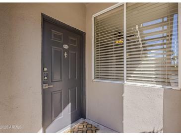 Inviting front entrance features a modern door with digital lock and large window, creating a warm and secure welcome at 7009 E Acoma Dr # 1044, Scottsdale, AZ 85254