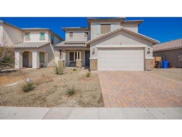 Charming two-story home featuring a two-car garage, desert landscaping, and welcoming front porch at 8430 W Atlantis Way, Tolleson, AZ 85353