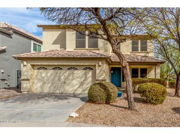 Charming home with a two-car garage, landscaped front yard and welcoming blue front door at 110 W Yellow Bee Dr, San Tan Valley, AZ 85143