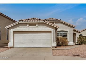 Charming single-story home with a two car garage, desert landscaping, and neutral stucco exterior at 11040 W Hayward Ave, Glendale, AZ 85307