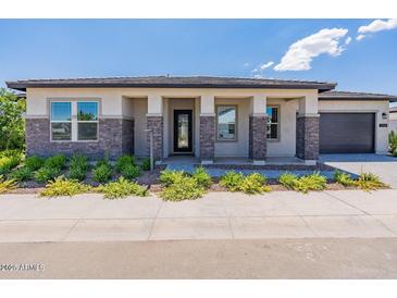 Charming home showcasing stone accents, a welcoming front porch, and manicured landscaping for curb appeal at 11188 N Blakely St, Surprise, AZ 85388