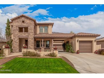 Beautiful two-story home with a lush front lawn, a stone facade, and a spacious three-car garage at 15322 W Montecito Ave, Goodyear, AZ 85395