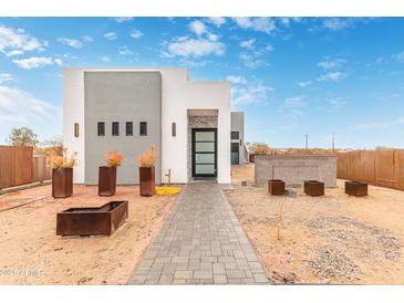 Modern, two-tone home with desert landscaping, visible with a paved walkway leading to the front door at 2940 E South Mountain Ave, Phoenix, AZ 85042