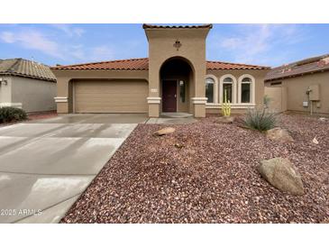 Charming single-story home showcasing a red-tiled roof, desert landscaping, and an attached two-car garage at 42618 W Oakland Dr, Maricopa, AZ 85138