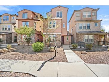 Charming townhome featuring stone accents, a well-maintained landscape, and a welcoming walkway to the front door at 7815 W Monte Vista Rd, Phoenix, AZ 85035