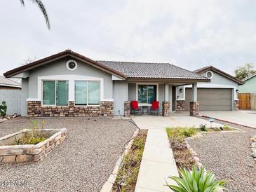 Charming single-story home featuring a well-kept xeriscaped front yard with inviting covered porch at 8139 W Columbine Dr, Peoria, AZ 85381