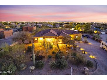 Expansive desert property with mature trees, landscape lighting, and scenic city views at dusk at 9331 E Mclellan Rd, Mesa, AZ 85207