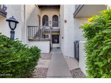 Charming condo entrance with private access stairs, landscaped grounds, and wrought iron details at 11011 N 92Nd St # 1157, Scottsdale, AZ 85260