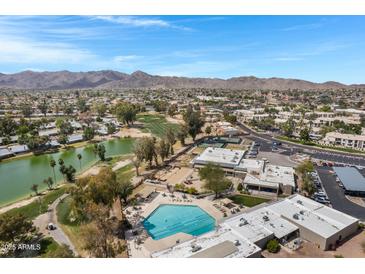 Scenic aerial view of the community showcasing the pool, golf course, and mountain views against a bright, blue sky at 12007 S Crow Ct, Phoenix, AZ 85044