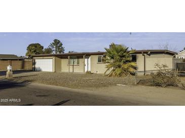 Front exterior of single-story home with desert landscaping, featuring an attached garage and traditional design at 1518 N Gilbert Ave, Casa Grande, AZ 85122