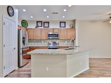 Spacious kitchen with stainless steel appliances, granite counters, and wood-look tile at 17062 N 184Th Dr, Surprise, AZ 85374