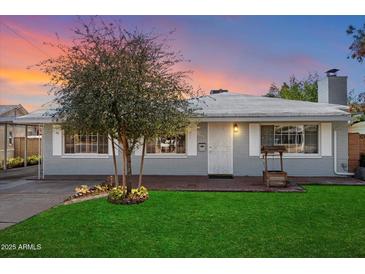 Charming single-story home featuring a well-manicured lawn, brick accents, and a mature shade tree at 2321 W Claremont St, Phoenix, AZ 85015
