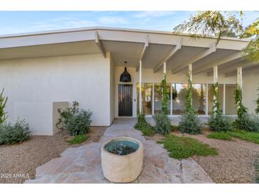 Inviting front entrance with a stone walkway and modern design elements at 37 Spur Cir, Scottsdale, AZ 85251