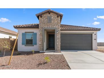 Charming single story home featuring a stone facade, 2-car garage, and low maintenance desert landscaping at 3937 S 233Rd Ln, Buckeye, AZ 85326