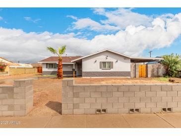 Charming single-story home with a palm tree, block wall, and a covered carport at 4031 N 81St Ave, Phoenix, AZ 85033