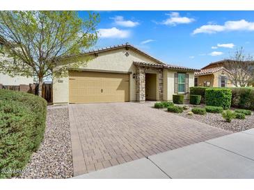 Charming home with a well-manicured front yard, brick driveway, and a two-car garage at 7769 S Reseda St, Gilbert, AZ 85298