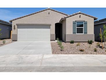 Charming single-story home featuring a two-car garage, desert landscaping, and neutral exterior paint at 8576 W Trenton Ct, Florence, AZ 85132