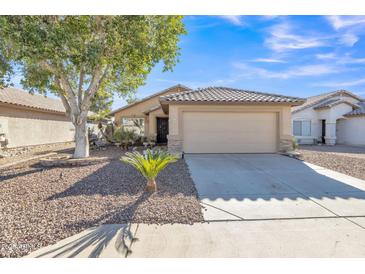 Inviting single-story home with desert landscaping, a mature shade tree, and a neutral-toned facade with a tiled roof at 9231 E Carmel Ave, Mesa, AZ 85208