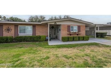 Charming single-story brick home with manicured landscaping and cozy curb appeal at 10417 W Deanne Dr, Sun City, AZ 85351