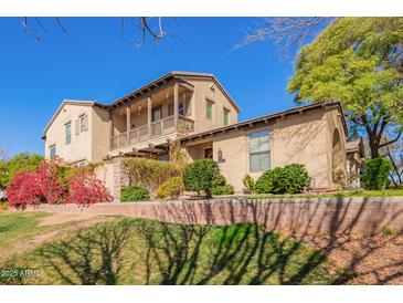 Stunning two-story home with a charming balcony and beautifully landscaped front yard, offering a welcoming atmosphere at 15239 W Alexandria Way, Surprise, AZ 85379
