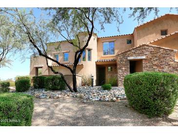 Attractive home exterior featuring a stone accent wall, desert landscaping, and a lovely entry at 19475 N Grayhawk Dr # 1018, Scottsdale, AZ 85255