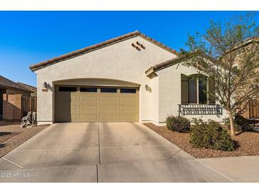 Beige stucco home with an attached 2 car garage, tile roof, and a well-maintained landscape at 21244 E Creekside Dr, Queen Creek, AZ 85142