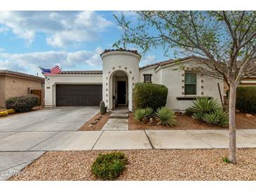 Charming home featuring a turret entryway, desert landscaping, and a two-car garage at 22452 E Calle De Flores --, Queen Creek, AZ 85142