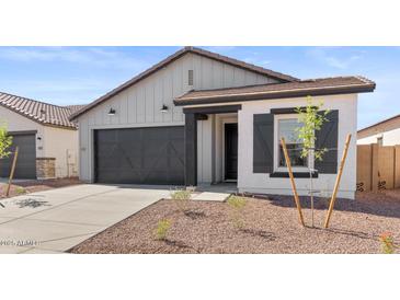 Charming single-Gathering home showcasing a gray facade, black trim, and a well-manicured front yard with a concrete driveway at 23435 W Albeniz Pl, Buckeye, AZ 85326