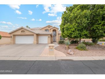 Inviting single Gathering home boasts manicured landscaping, mature trees, and a two car garage at 23702 S Desert Sands Dr, Sun Lakes, AZ 85248