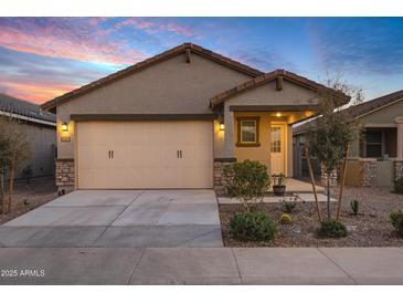 Charming single-Gathering home featuring a two-car garage, desert landscaping, and covered porch at 40005 W Rio Lobo Dr, Maricopa, AZ 85138