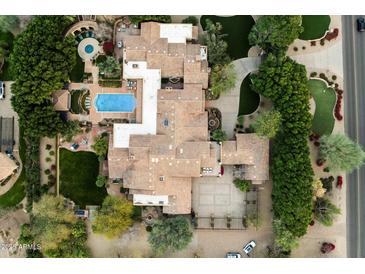 Expansive property featuring a tile roof, manicured lawns, a large pool, and a circular driveway at 6402 E Chaparral Rd, Paradise Valley, AZ 85253