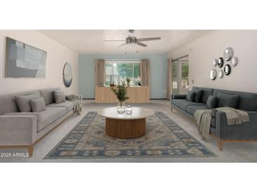 Bright living room featuring stylish sofas, modern decor, and a large area rug over carpet at 12939 W Prospect Dr, Sun City West, AZ 85375