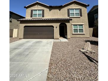 Two-story home featuring a brown garage door, neutral stucco exterior and low maintenance gravel landscaping at 36992 W Capri Ave, Maricopa, AZ 85138