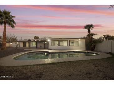Backyard pool and patio with palm trees and updated home exterior at dusk at 4410 N 20Th Ave, Phoenix, AZ 85015