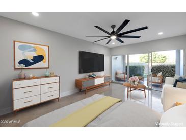 This staged bedroom boasts a ceiling fan, patio access, modern décor, and neutral color palette at 6125 E Indian School Rd # 131, Scottsdale, AZ 85251