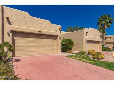 Single-story stucco home with a two-car garage and a tile driveway in a desert landscape at 7955 E Chaparral Rd # 120, Scottsdale, AZ 85250