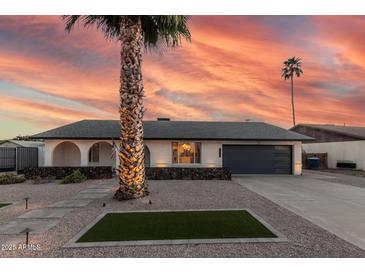 Charming single-story home with a well-manicured yard, desert landscaping, and modern garage door at 1949 E Oxford Dr, Tempe, AZ 85283